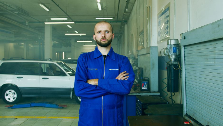 Professional mechanic in a repair shop, focused on car maintenance and vehicle service.